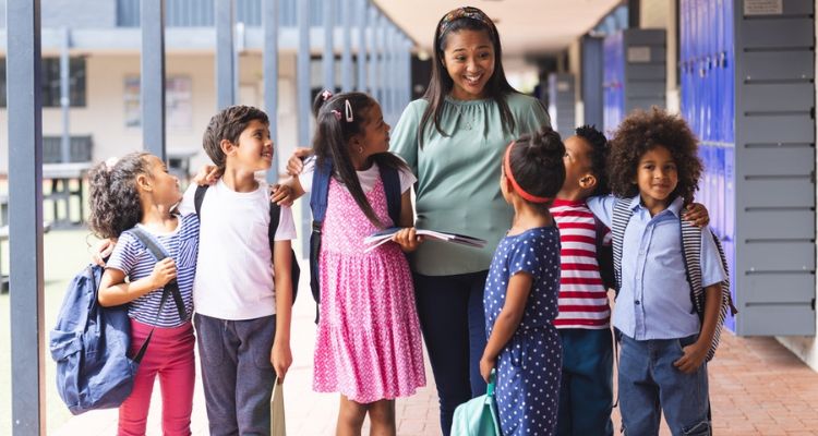 a group of happy school children walking with a teacher